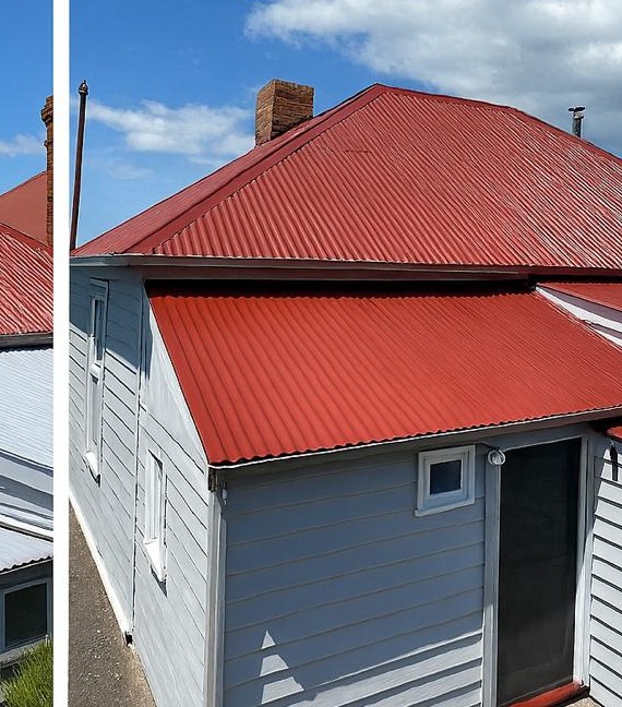 Grey weatherboard home with a freshly painted red metal roof