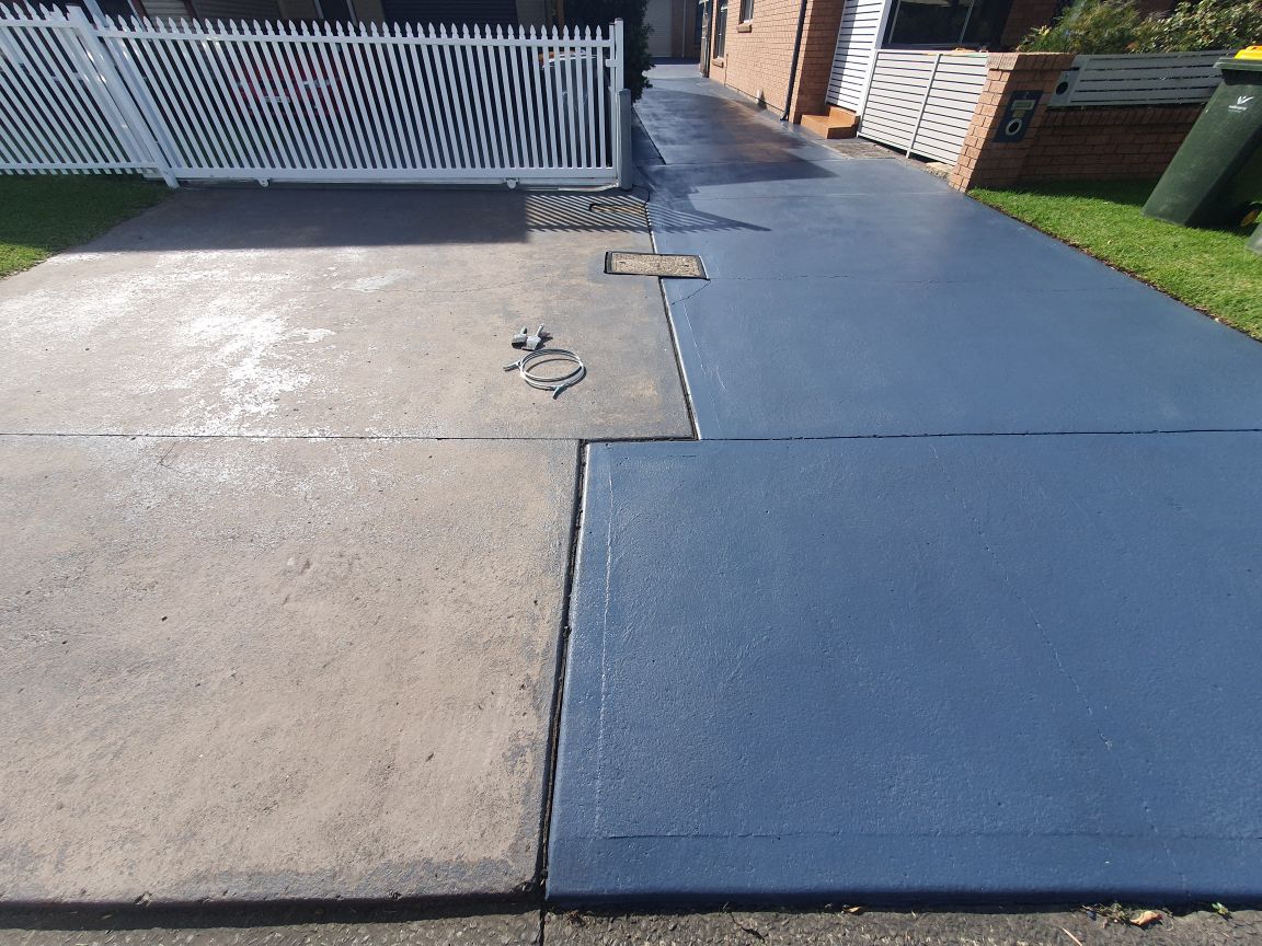 Driveway coating in progress showing bare concrete beside freshly coated grey concrete
